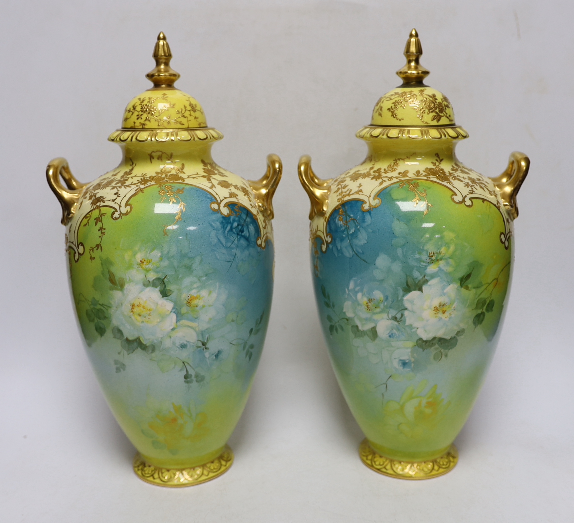 A pair of Royal Bonn flower painted earthenware vases and covers, 34cm